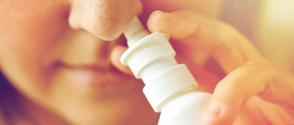 Close Up Sick Woman Using Nasal Spray - ( Natural News ) Najwyższy organ sanitarny w Hiszpanii, Agencja Leków i Produktów Zdrowotnych (AEMPS),  zakazał sprzedaży sprayu do nosa za 51 funtów, który twierdzi, że chroni przed COVID-19 .